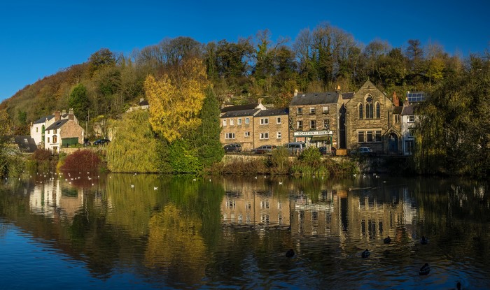 Houses on a riverbank in Cromford, Derbyshire, England