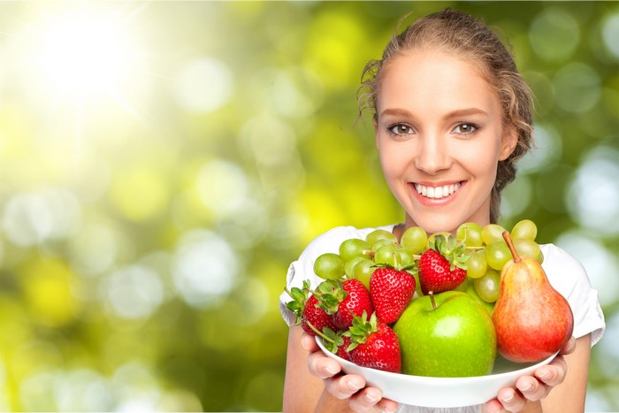 Woman holding a bowl of fruit