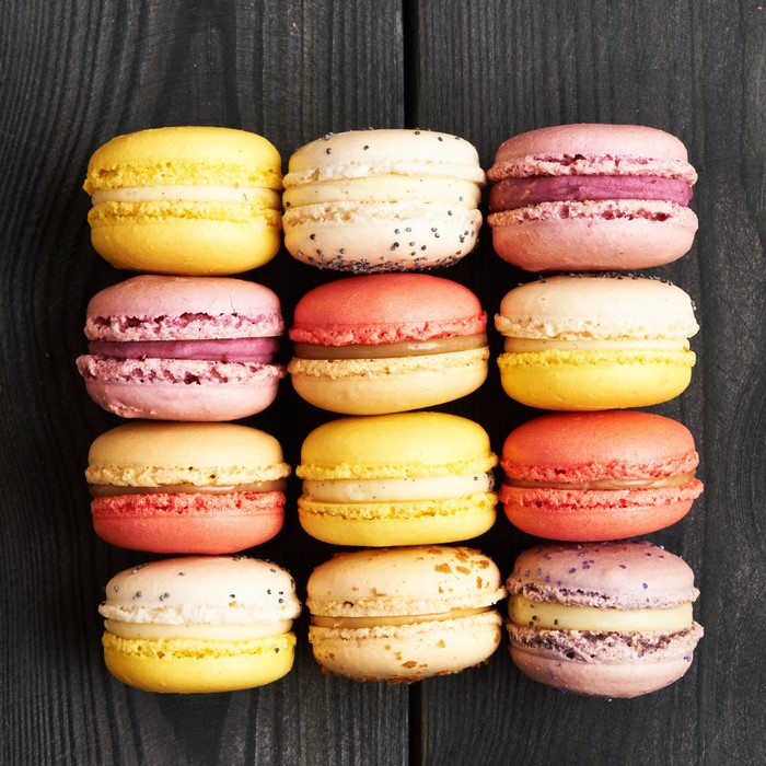Assortment of colorful macarons on a dark wooden surface