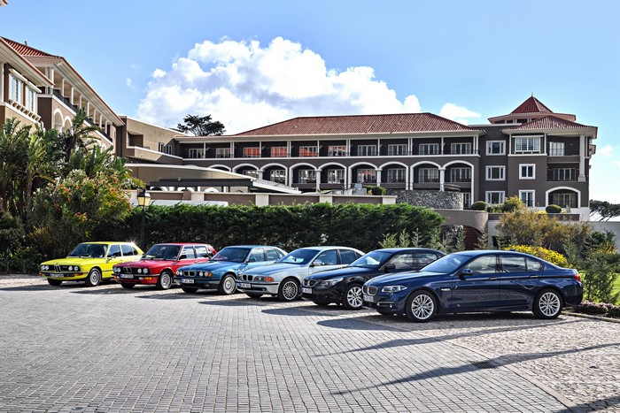 BMW 5 Series cars parked in front of a hotel