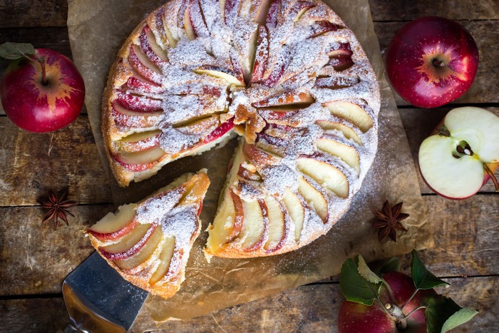Apple pie with powdered sugar and apples