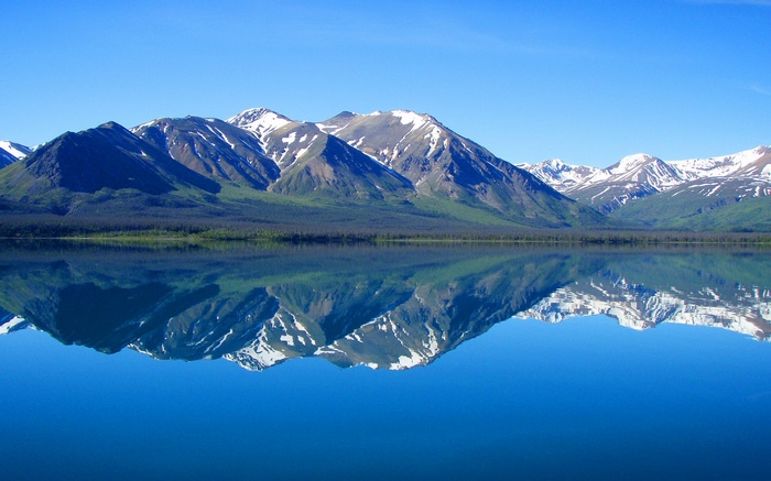 Snow-capped mountains reflected in a calm lake