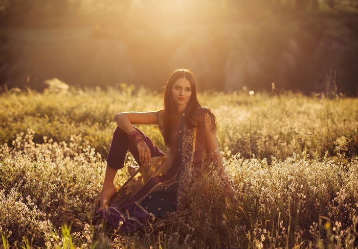 Woman in traditional Indian clothing sitting in a field