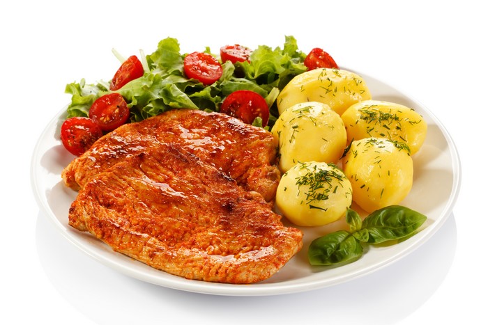 Meat products with potatoes and salad on a plate