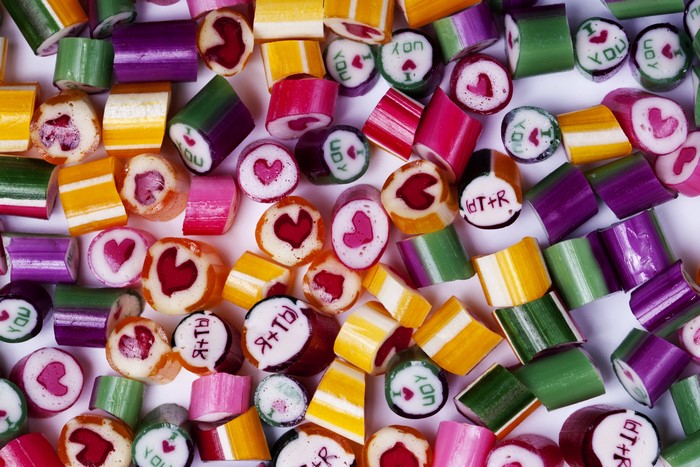 Many colorful candies with hearts and text
