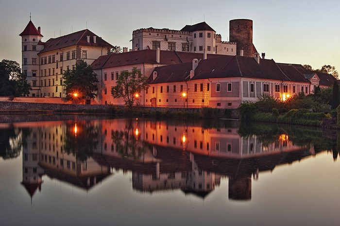 Jindrichuv Hradec castle reflected in water at dusk