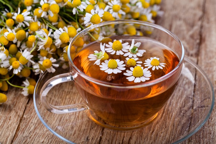 Chamomile tea in a cup with chamomile flowers