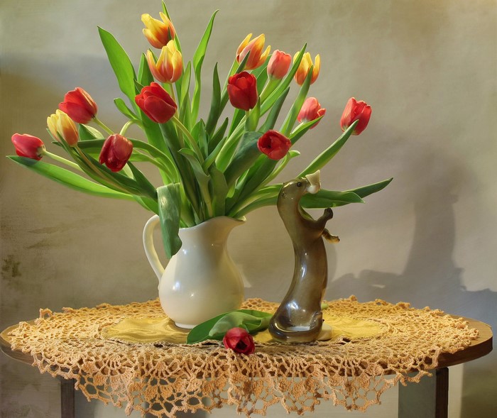 Tulips in a vase with a figurine