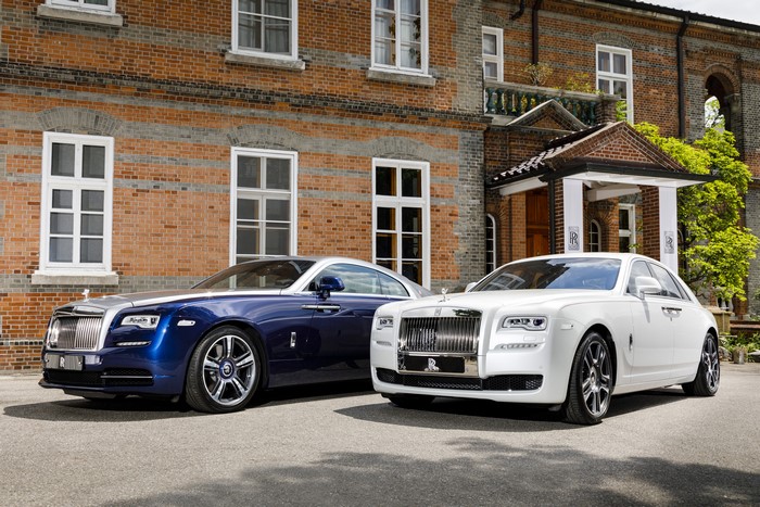 Two Rolls-Royce cars in front of a brick building