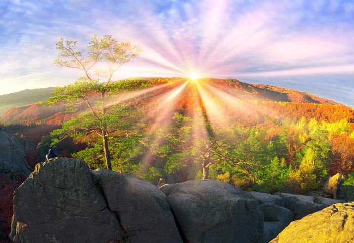 Sunrise over autumn mountains in Ukraine with sun rays