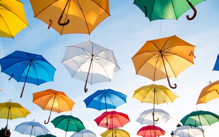 Many colorful umbrellas suspended in the sky