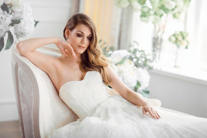 Bride with brown hair sitting on a couch