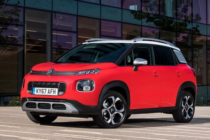 Red 2017 Citroen C3 Aircross parked in front of a modern building