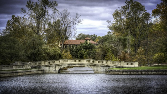 Stone bridge over water with building and trees