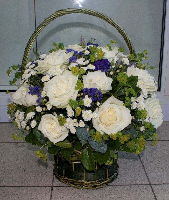 White roses and small flowers in a wicker basket