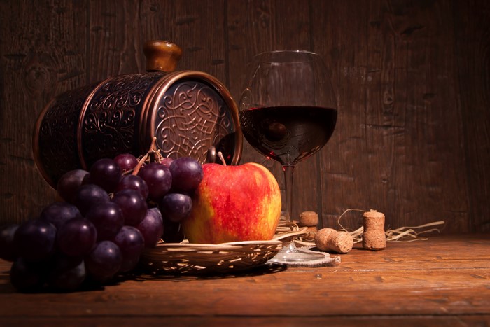 Still-life with wine barrel, grapes, apple, and wine glass