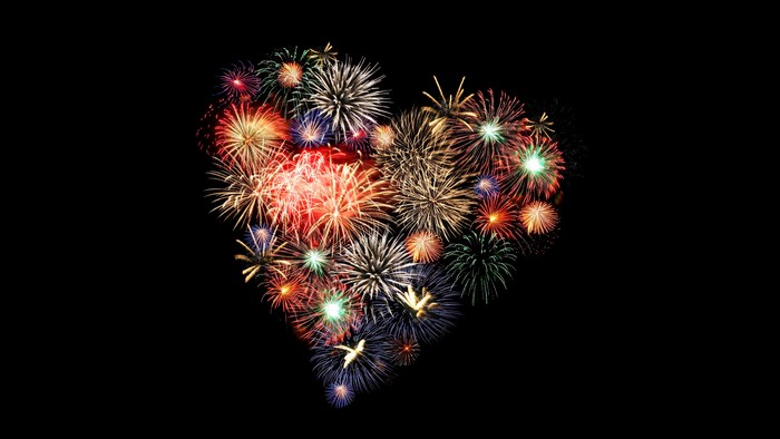 Heart shape made of fireworks on black background