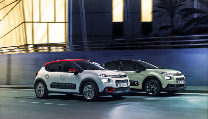 Two Citroen C3 cars driving on a road