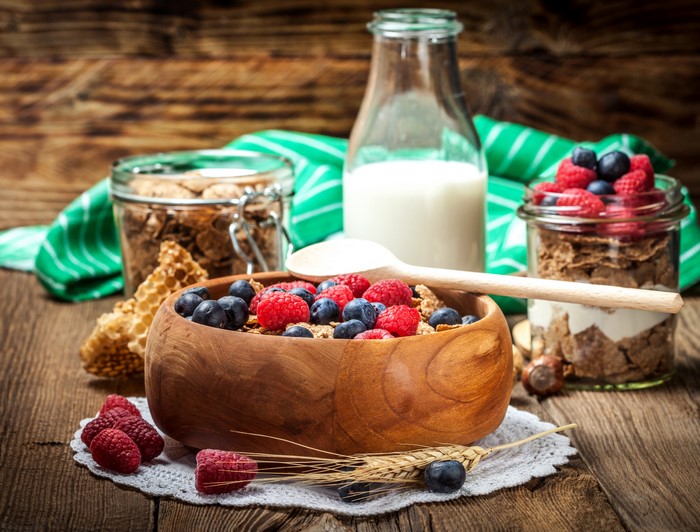 Cereal with berries and milk on a wooden table