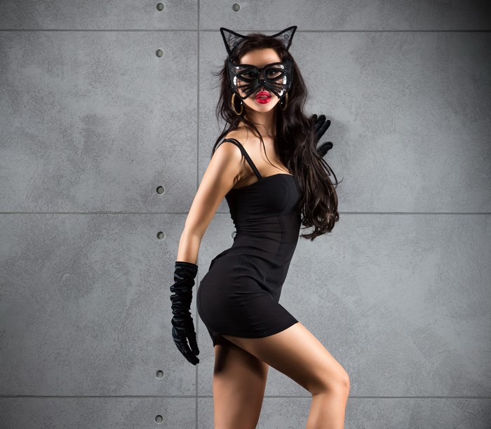Woman in black dress and cat mask