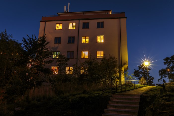 Apartment building at night with illuminated windows and stairs