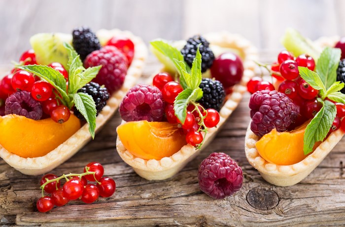 Three fruit tarts with berries and kiwi