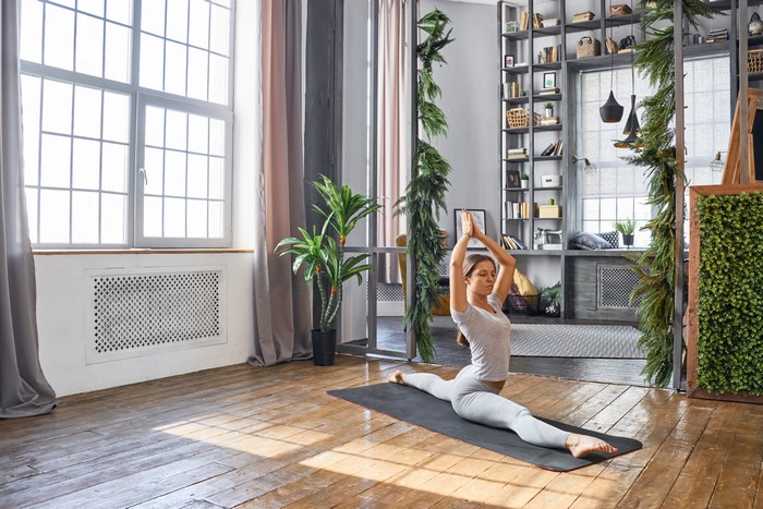 Woman doing a yoga split on a mat