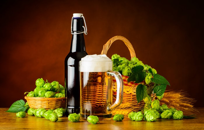 Beer bottle, mug, hops, and wheat in a basket