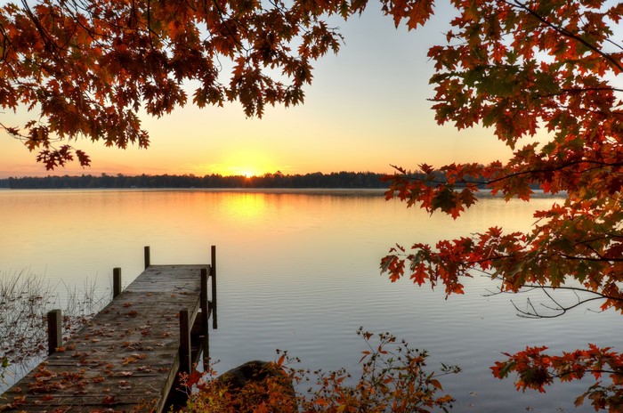 Autumn sunrise over a lake with a wooden dock