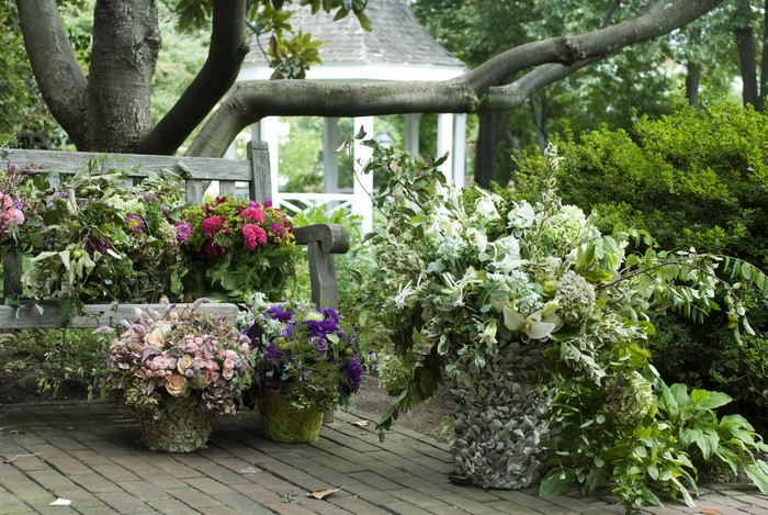 Garden bouquets on a wooden bench and pots