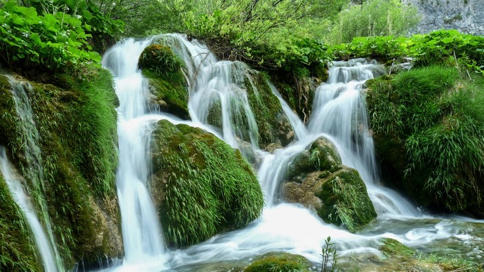 Waterfalls cascading over moss-covered rocks in Plitvice National Park, Croatia