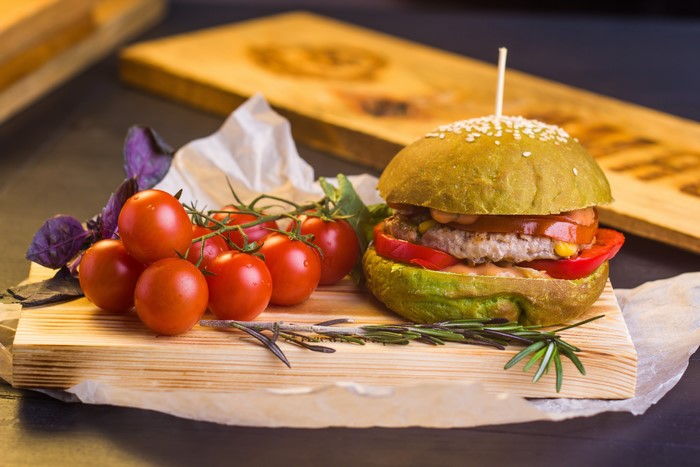 Hamburger with Tomatoes on Cutting Board