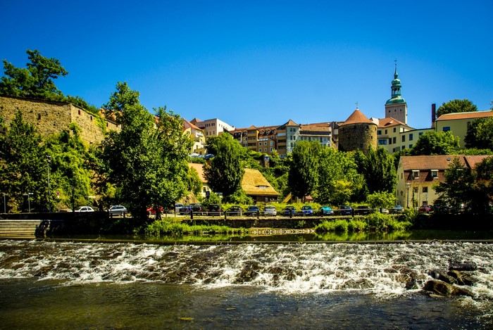 River flowing past a historic town with a castle and church