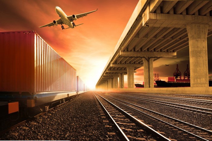 Airplane, Railroads, and Shipping Containers at Sunset