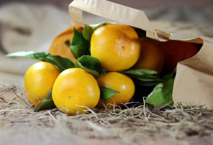 Mandarins in a paper bag with leaves