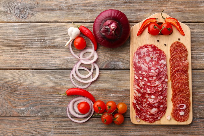 Sliced Salami, Onion, Tomatoes, and Chili Peppers on Wood