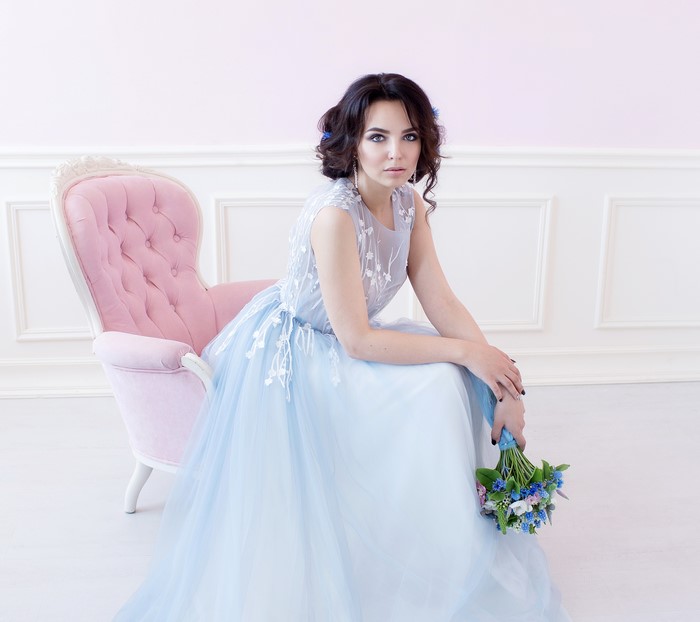 Brunette bride in a blue dress with a bouquet