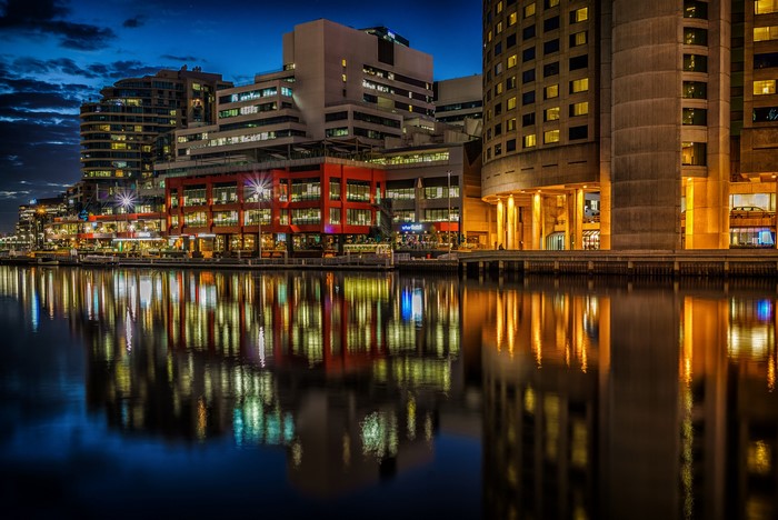 City buildings reflected in water at night