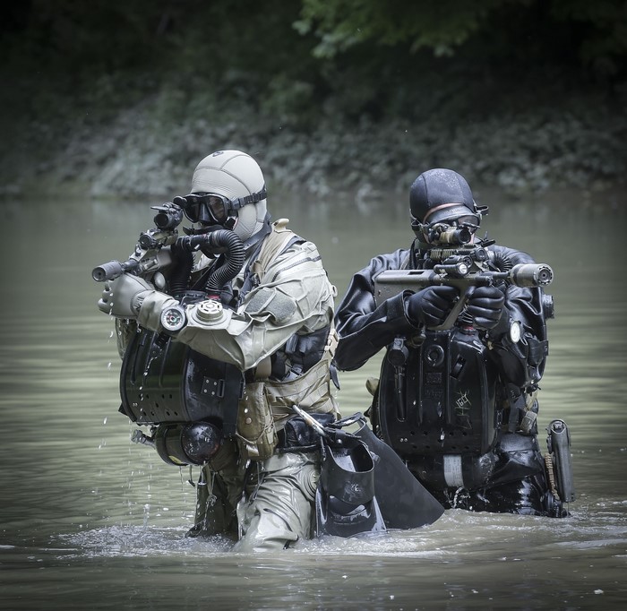 Special Forces soldiers with assault rifles in water