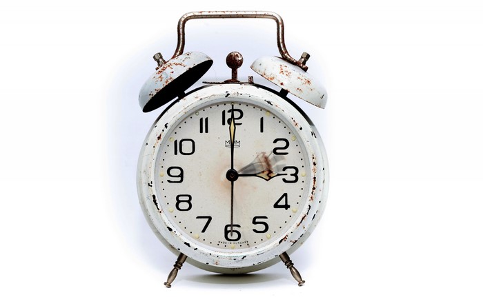 Close-up of a rusty white alarm clock