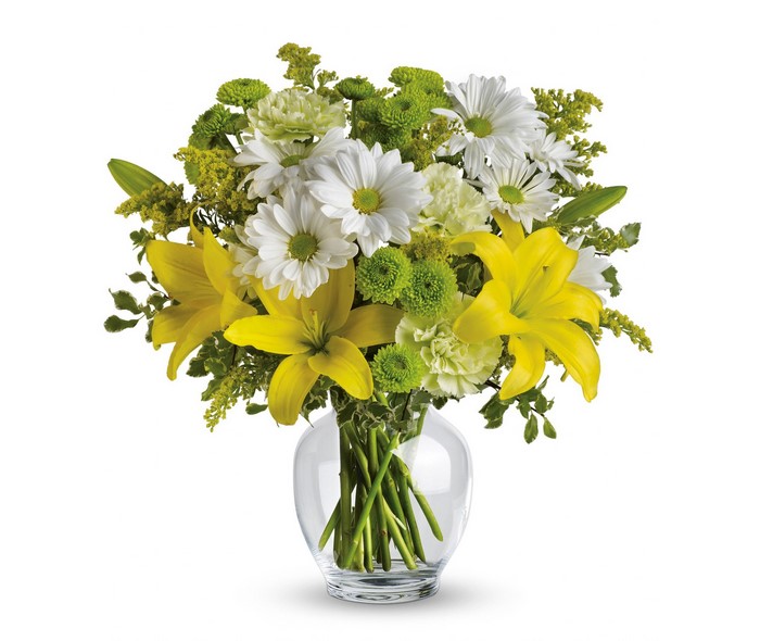 Yellow lilies and white daisies in a glass vase
