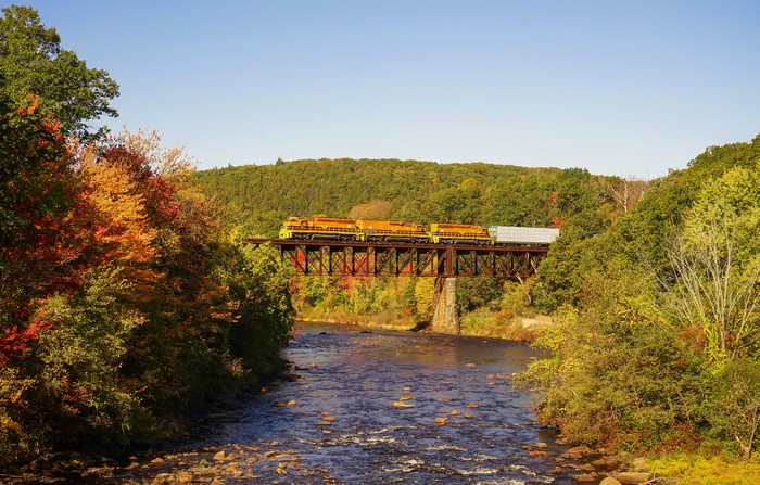Train crossing a bridge over a river in Autumn, Massachusetts, USA