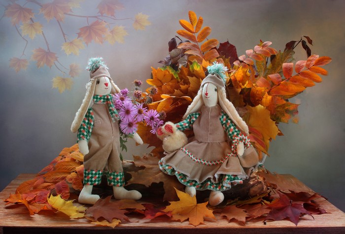 Two bunny dolls in autumn foliage