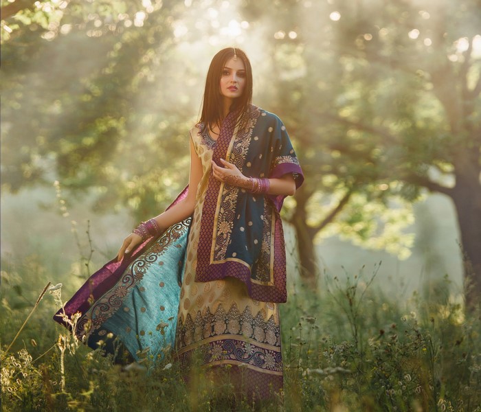 Woman in traditional Indian attire in a sunlit forest
