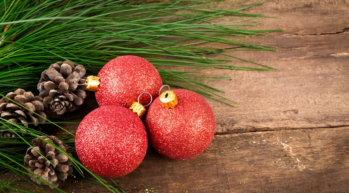 Christmas pine cones and red ornaments on wood