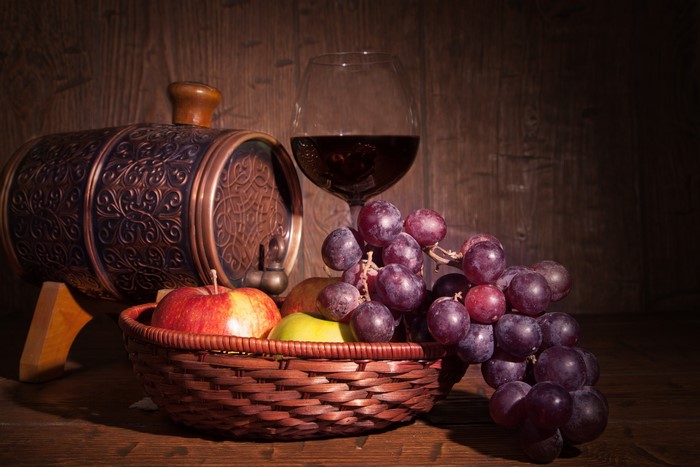 Still life with wine barrel, grapes, apples, and wine glass