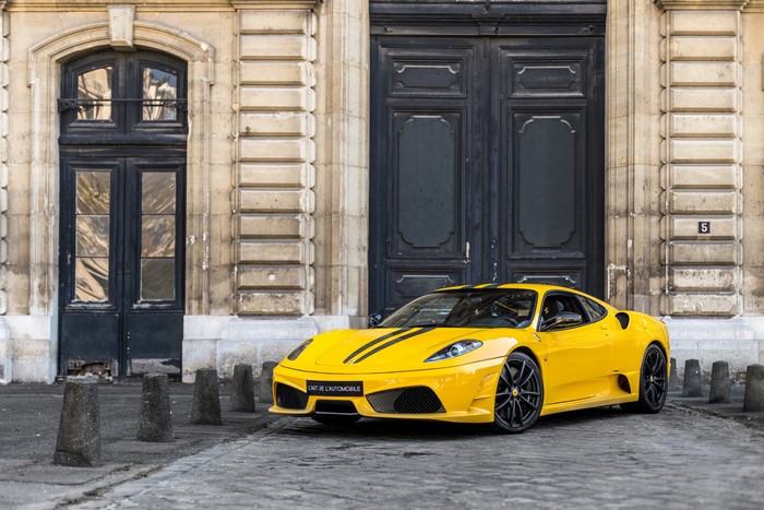 Yellow Ferrari 430 Scuderia parked in front of a building