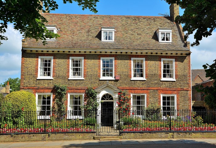 Brick house with white windows and a garden in Ely, England