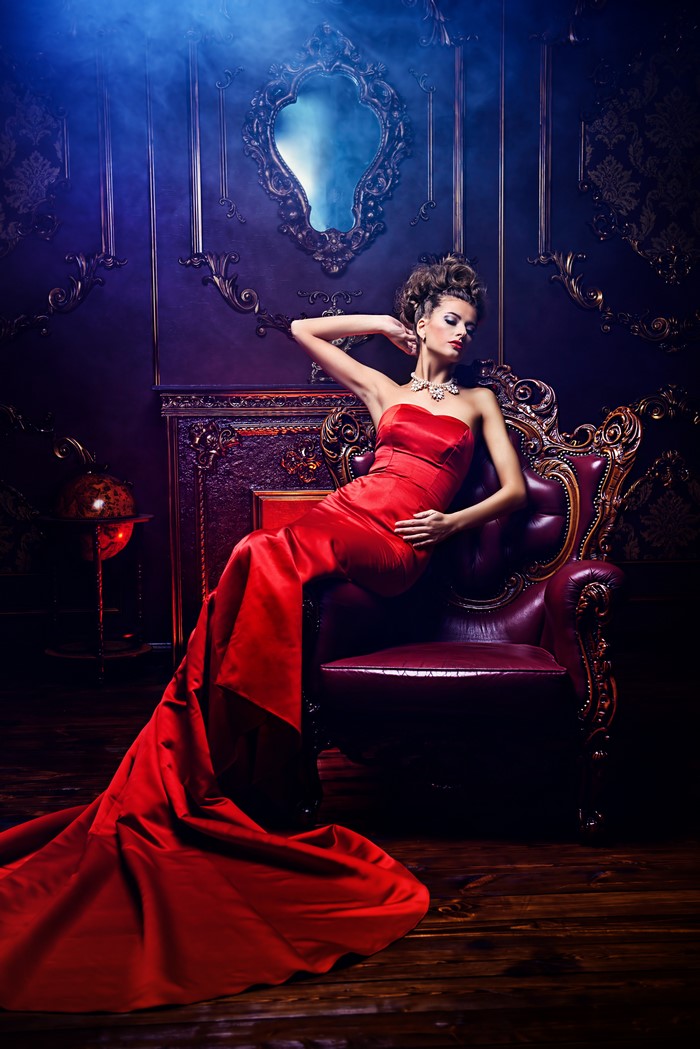 Woman in red dress sitting in armchair