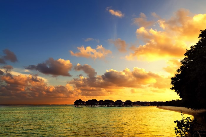 Overwater bungalows at sunset in the Maldives